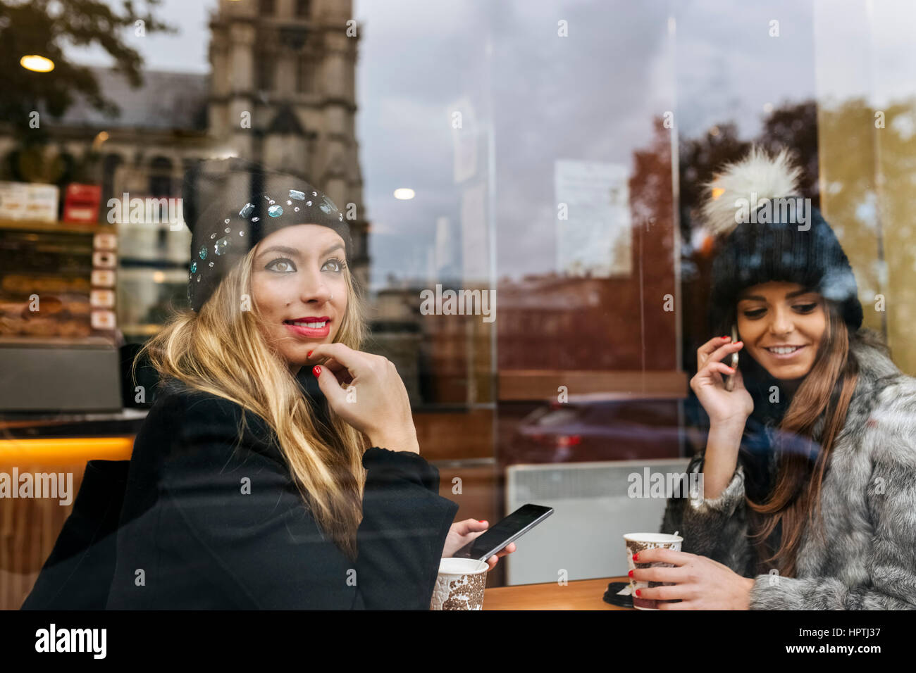 Francia, Parigi, due amici seduti in un caffè vicino alla cattedrale di Notre Dame Foto Stock