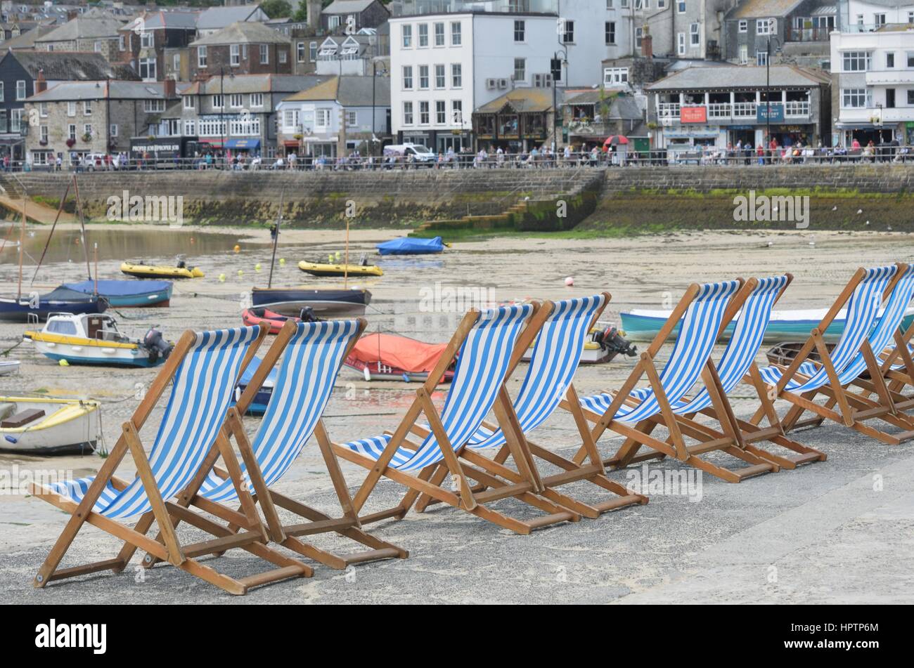 St Ives Cornwall , Regno Unito - Luglio 03, 2016: Linea di sedie a sdraio con città in background Foto Stock