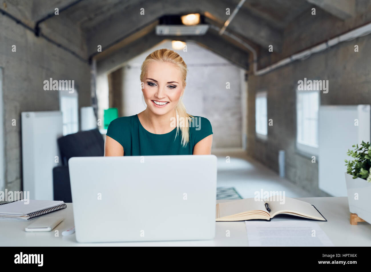 Felice imprenditrice lavorando sul computer portatile in ufficio moderno, avviare il nuovo concetto di business Foto Stock