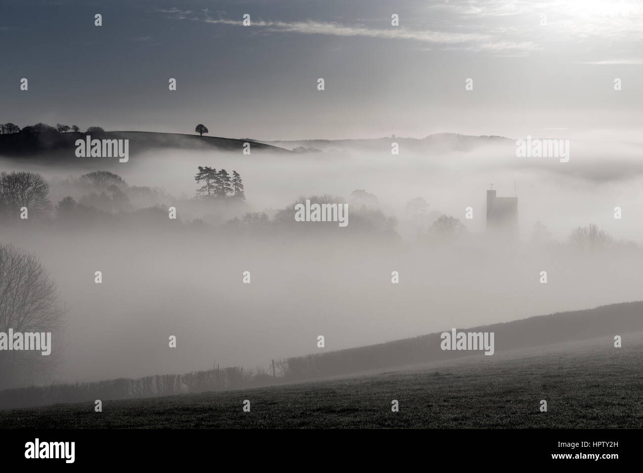 La nebbia rotoli su un combe o coombe una valle contenente il villaggio di Dunsford nella valle Teign,Cob e paglia imbiancato,Parco Nazionale di Dartmoor Foto Stock