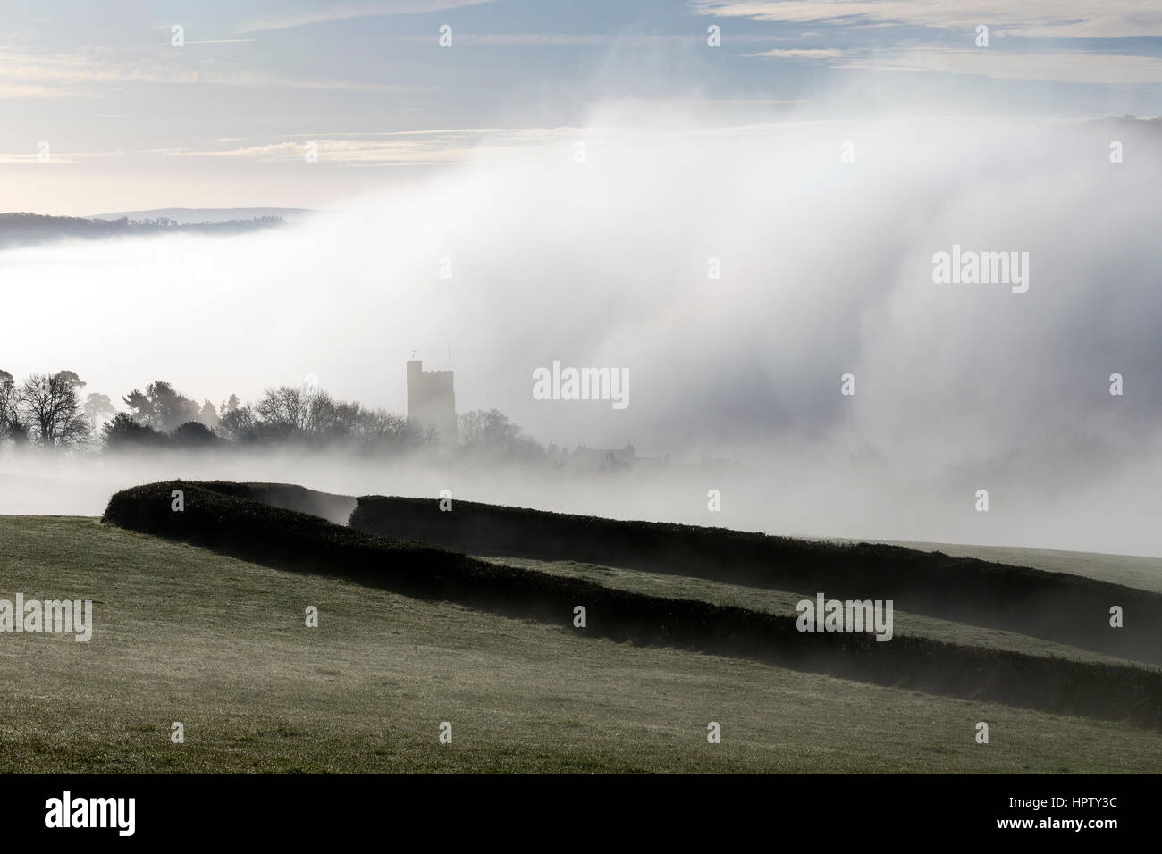 La nebbia rotoli su un combe o coombe una valle contenente il villaggio di Dunsford nel Teign Valley, pannocchie e paglia imbiancato ,,Parco Nazionale di Dartmoor Foto Stock