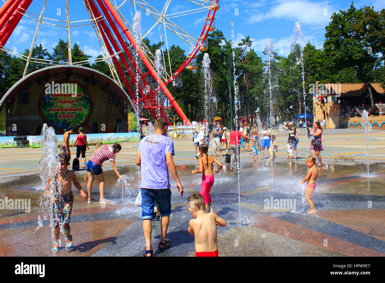 I bambini che giocano nel parco giochi con i loro genitori con fontane in Gorky Park in Kharkiv Foto Stock