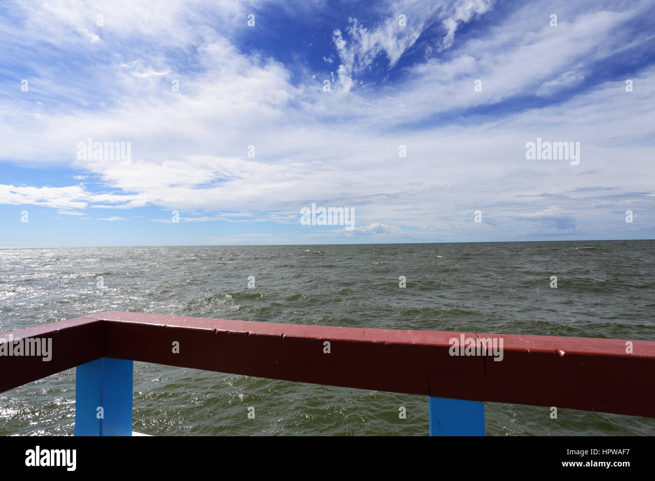 Acqua di mare e di un cielo estivo blu con la rotaia metallica sulla parte anteriore Foto Stock