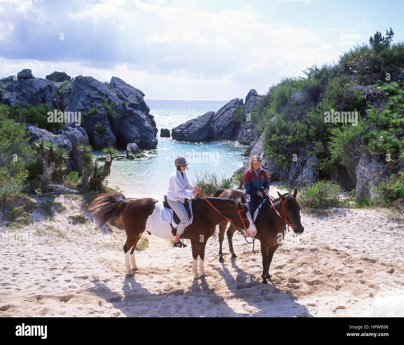 Le donne a cavallo sulla spiaggia, Jobson's Jobson's Cove, Warwick Long Bay, South Shore, Warwick Parish, Bermuda Foto Stock