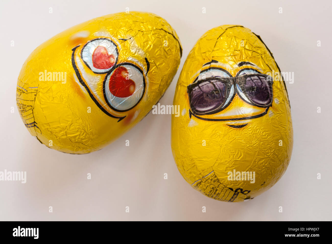 Due Toto gli Emoji latte uova di cioccolato con sorpresa giocattoli pronto per Pasqua isolato su sfondo bianco Foto Stock