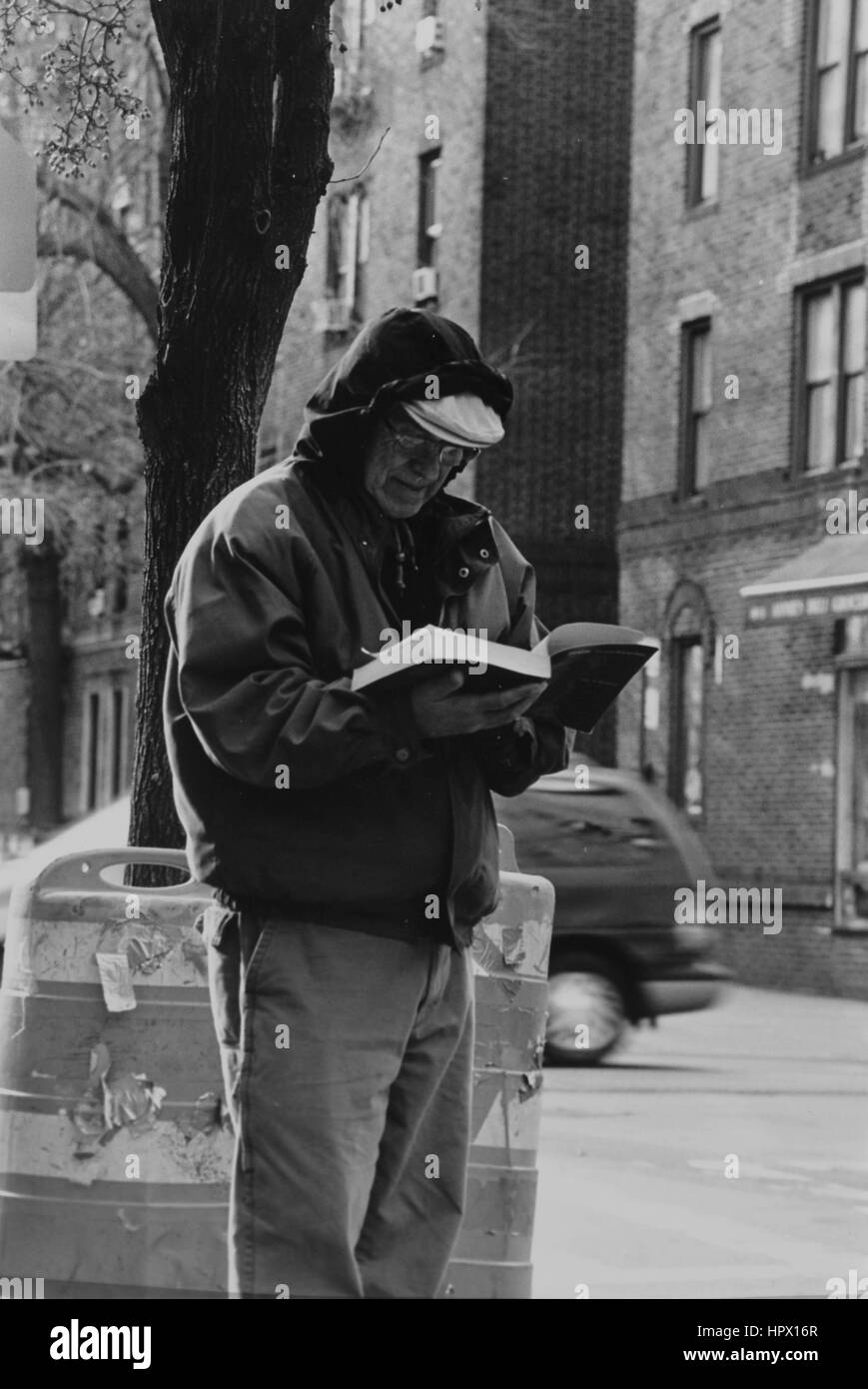 Un uomo che legge un libro in Jackson Heights Foto Stock