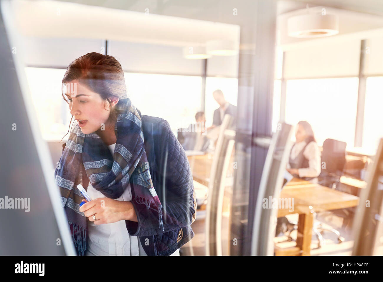 Imprenditrice scrivere sulla lavagna della sala conferenze Foto Stock
