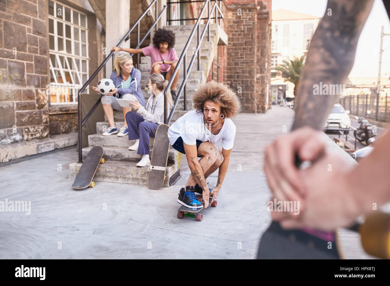 Gli amici lo skateboard e appendere fuori circa urbano passi Foto Stock