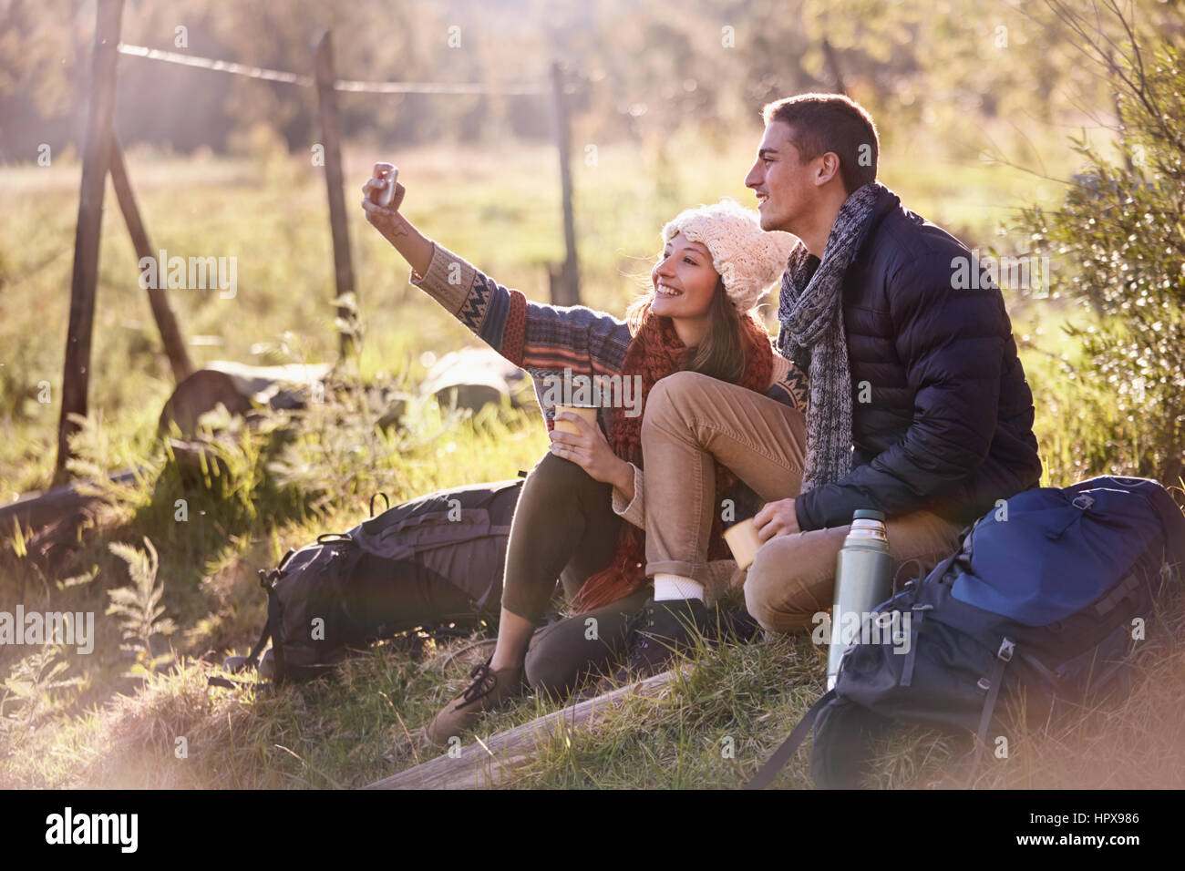 Coppia giovane prendendo una pausa da escursionismo, tenendo selfie con la fotocamera del telefono Foto Stock