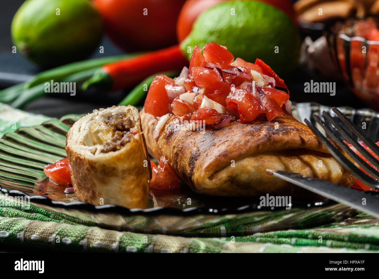 Chimichanga messicano con salsa dip su una piastra Foto Stock