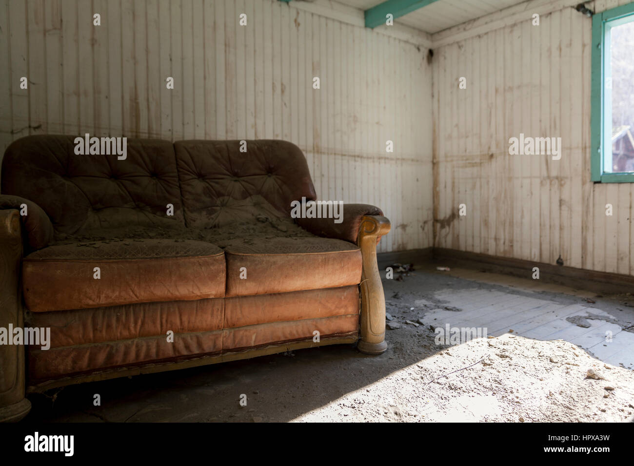 Il vecchio divano di pelle in una casa abbandonata Foto Stock