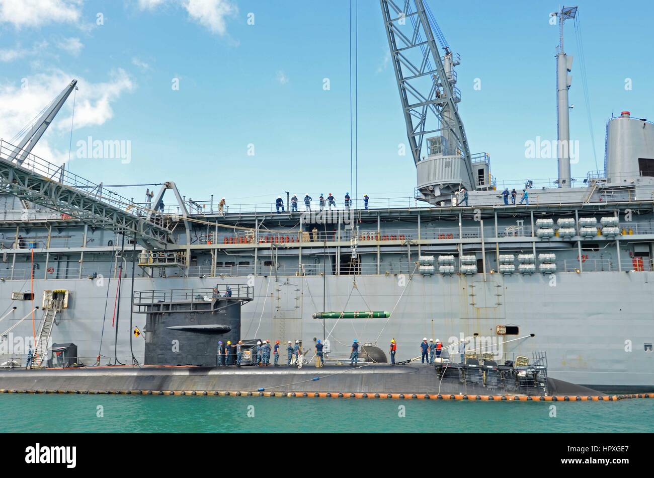 I marinai e servizio civile mariners assegnato al sommergibile offerta USS Frank Cable assistere i marinai a bordo del sottomarino USS Oklahoma City con siluro di offload, Novembre 14, 2012. Immagine cortesia Chris Salisbury/US Navy. Foto Stock