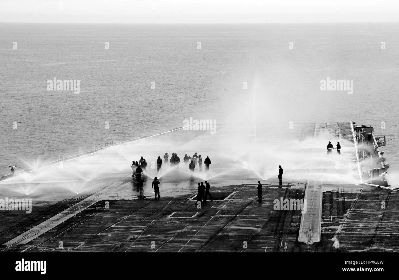 I marinai a bordo della portaerei USS Nimitz prendere parte in un contatore di misurare il lavaggio sul ponte di volo, 15 novembre 2012. Immagine Chris Bartlett/US Navy. Foto Stock