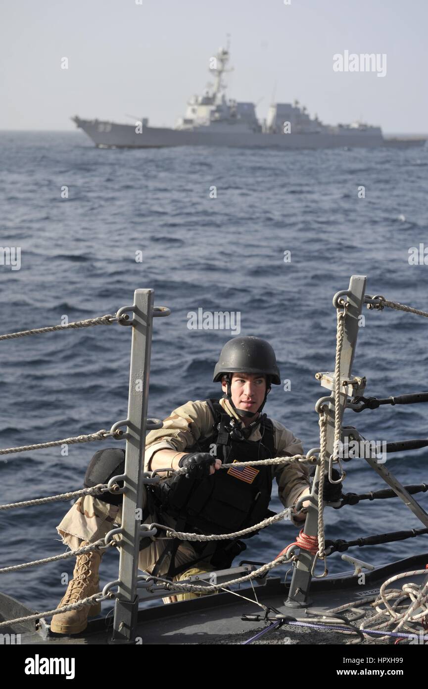 Specialista della logistica Brandon schede Highwood guidato un missile destroyer USS Jason Dunham durante un esercizio per la visita, scheda, ricerca e sequestro di team, 16 gennaio 2013. Immagine cortesia US Navy. Foto Stock