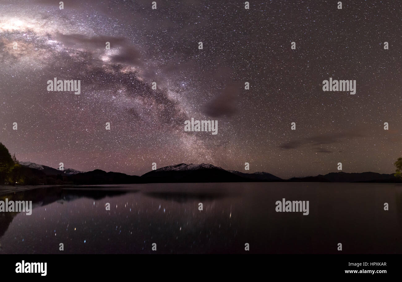 Scena Notturna, lago Wanaka con le stelle e la Via Lattea, stelle mirroring nell'acqua, Glendhu Bay, Otago Southland, Nuova Zelanda Foto Stock