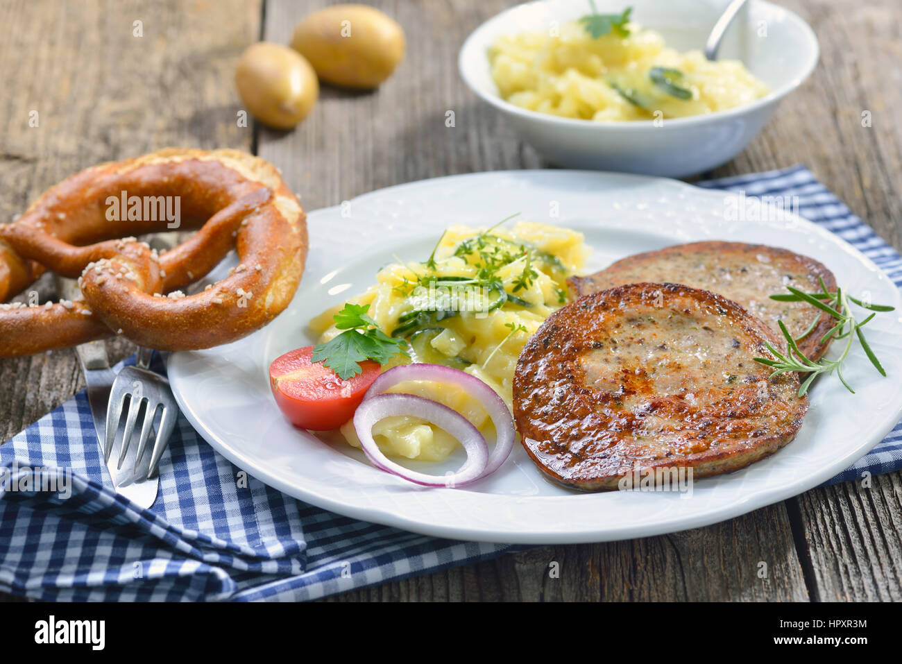 Cibo bavarese: fritto le fette di salsiccia con pezzi di milza di maiale (cosiddette "ilzwurst') servito con insalata di patate Foto Stock