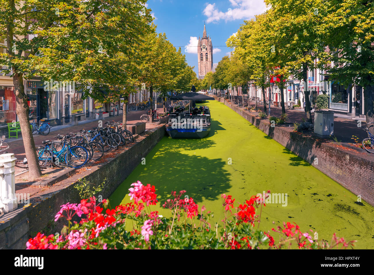 La pittoresca Oude Delft canal e torre pendente di protestante gotica Oude Kerk chiesa in una giornata di sole in Delft, South Holland, Paesi Bassi. Foto Stock