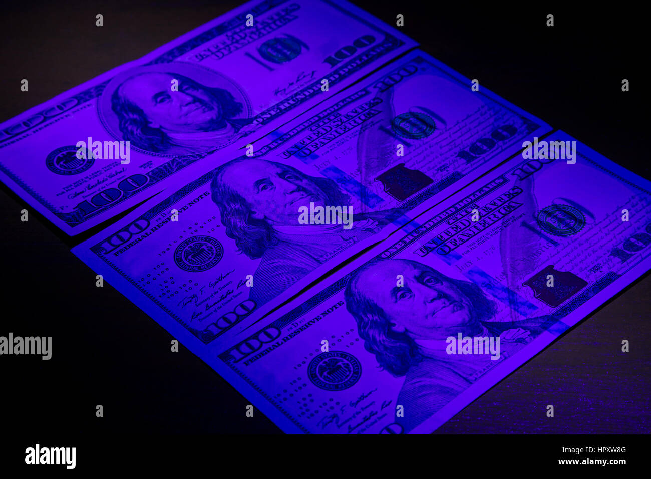 Trecento le fatture del dollaro sotto luce ultravioletta. Foto Stock