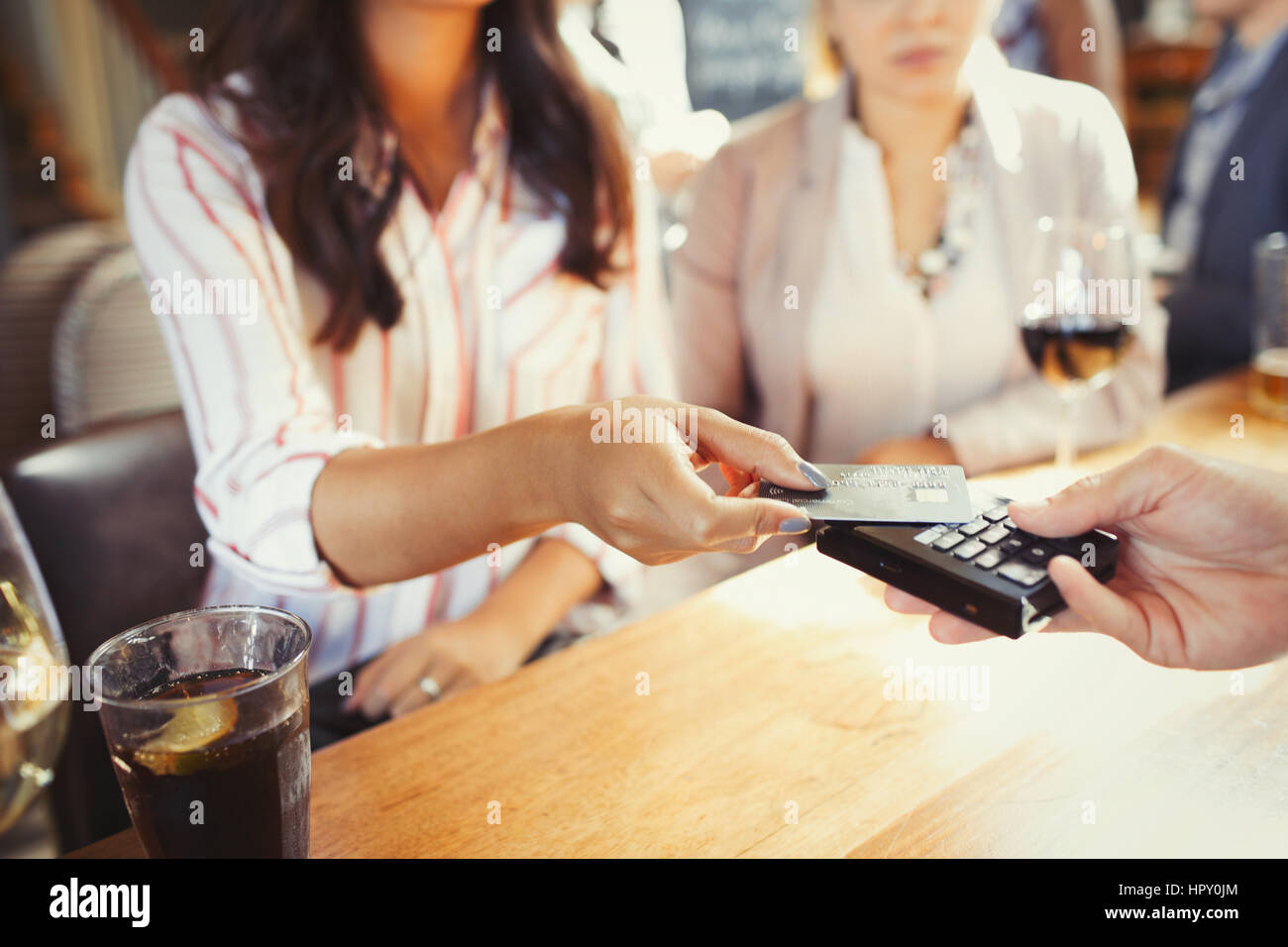 Donna barista pagando con carta di credito il pagamento senza contatto presso il bar Foto Stock