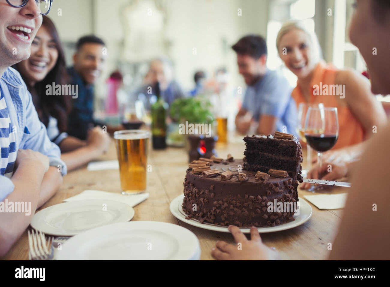 Donna che serve al cioccolato torta di compleanno con gli amici presso il ristorante la tabella Foto Stock