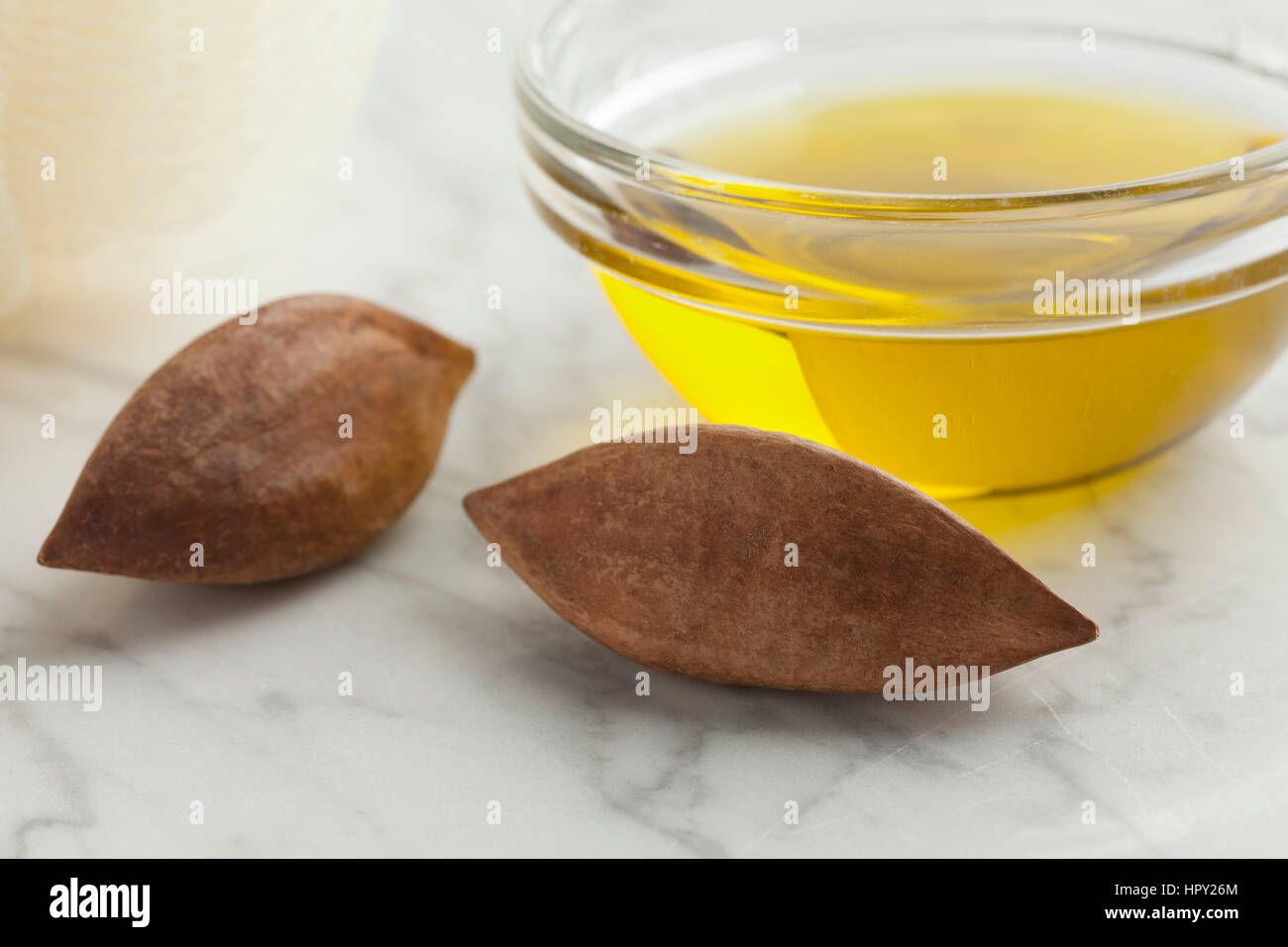 Vaso di vetro con Pili olio di noci intere e dadi pili Foto Stock