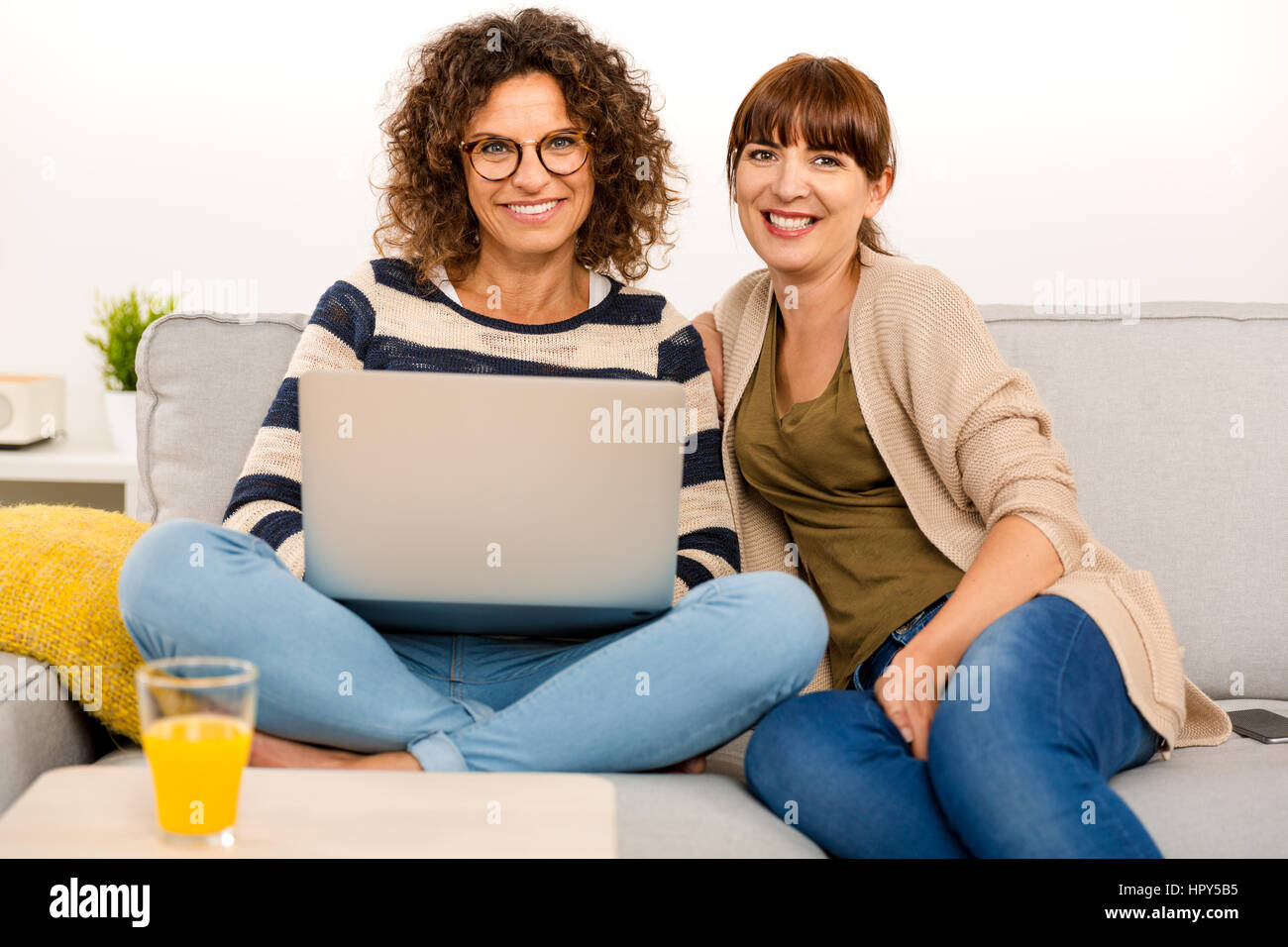 Due belle donne in casa a lavorare con un laptop Foto Stock