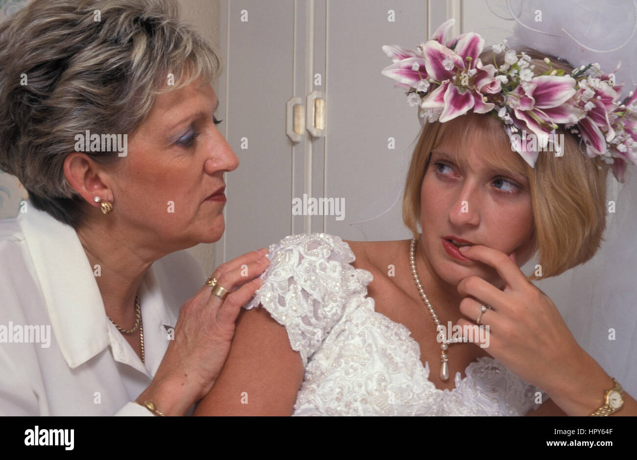 Ansioso giovane sposa che si è avvicinato da donna matura/sua madre Foto Stock