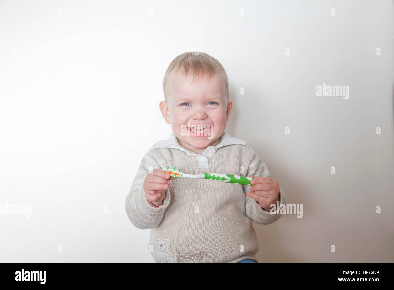 Bambina spazzolare i suoi denti isolati su sfondo bianco Foto Stock