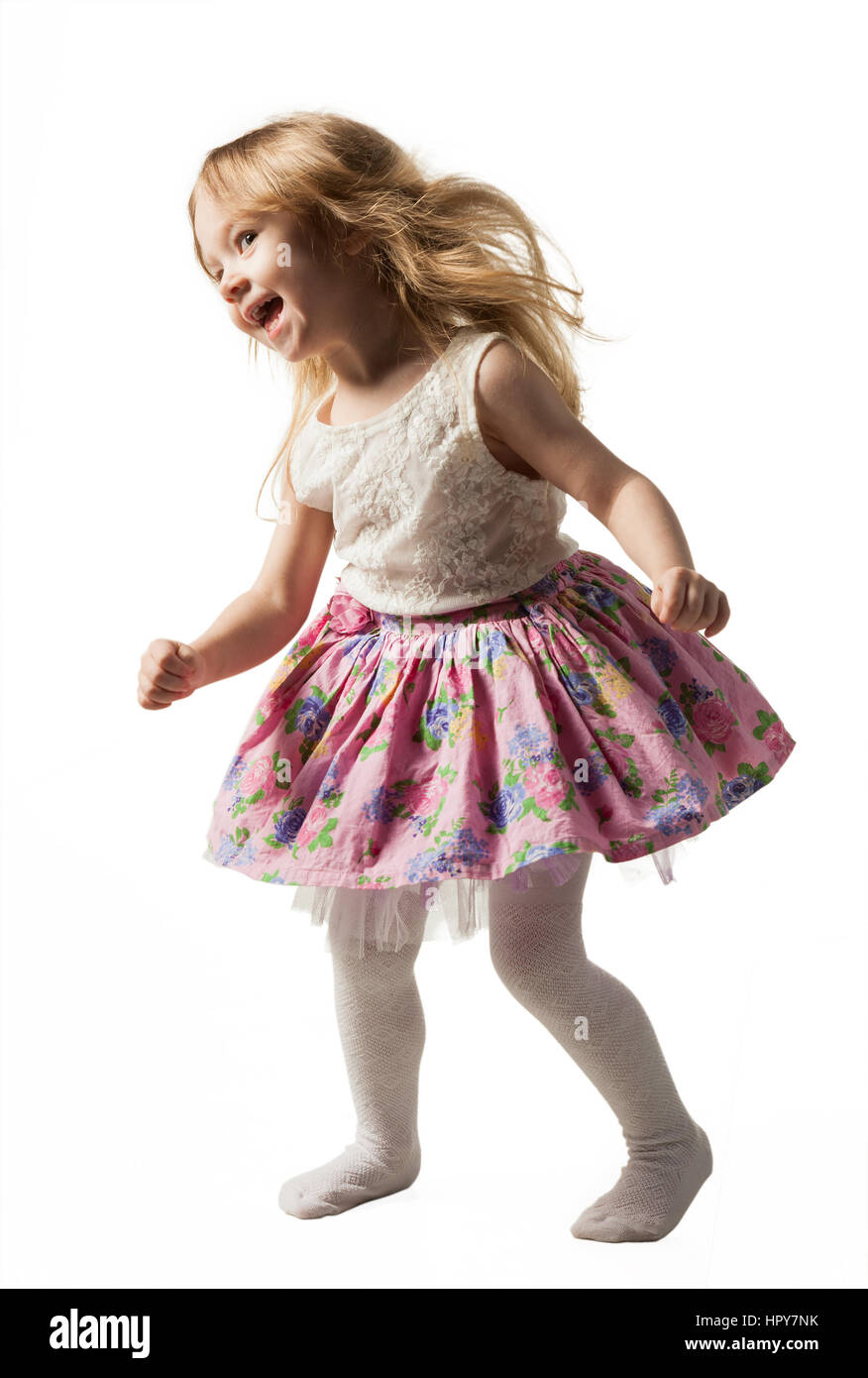 Poco carino ragazza jumping, acceso, dancing, divertendosi. Isolato su sfondo bianco Foto Stock