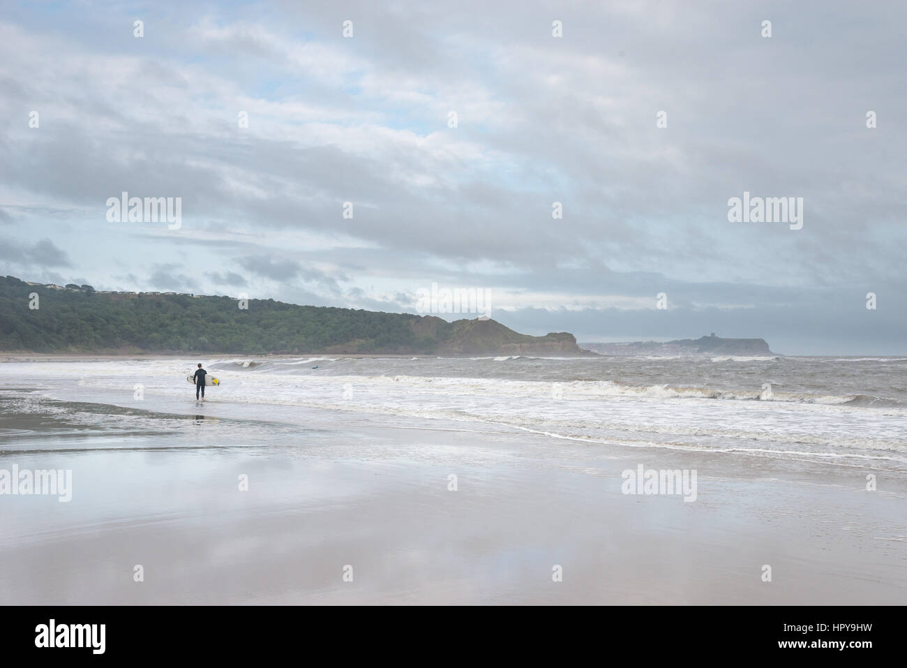Surfer sulla spiaggia di Baia Cayton vicino a Scarborough, North Yorkshire, Inghilterra. Foto Stock