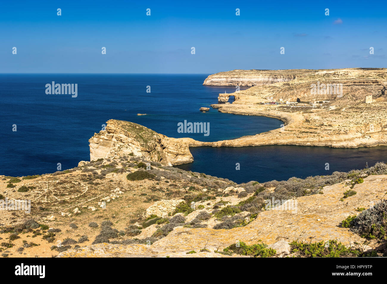 A Gozo, Malta - Vista panoramica del famoso Azure Window con la roccia del fungo e Dwejra Bay su una bella giornata estiva con cielo blu chiaro Foto Stock