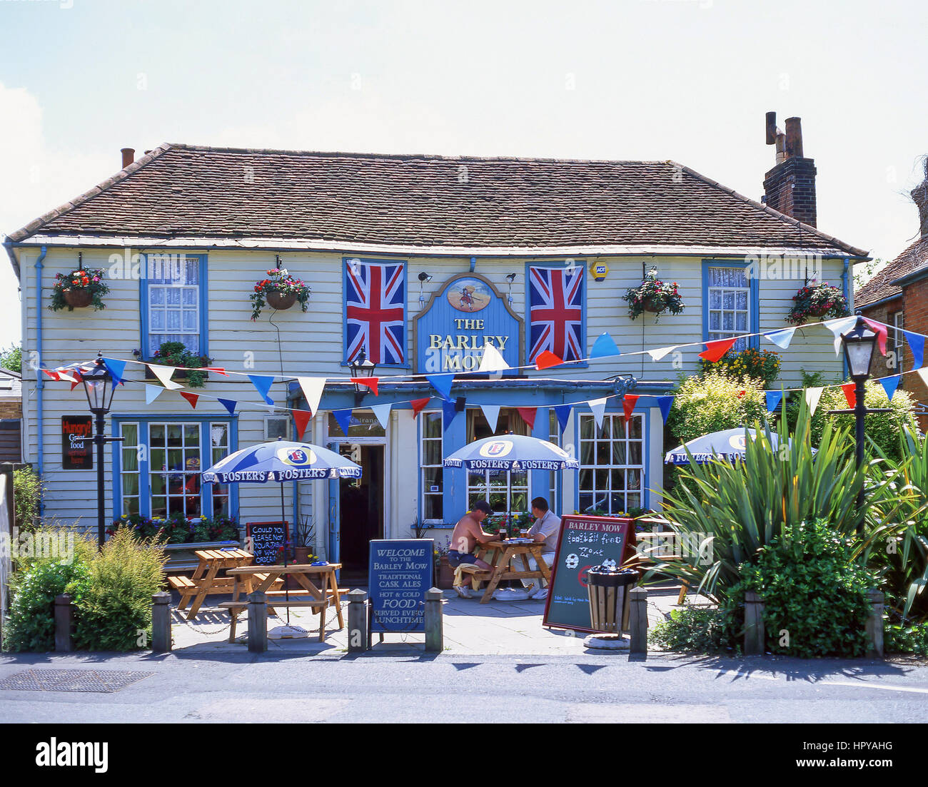 Xviii secolo orzo Mow pub con bunting, il verde, Englefield Green, Surrey, England, Regno Unito Foto Stock