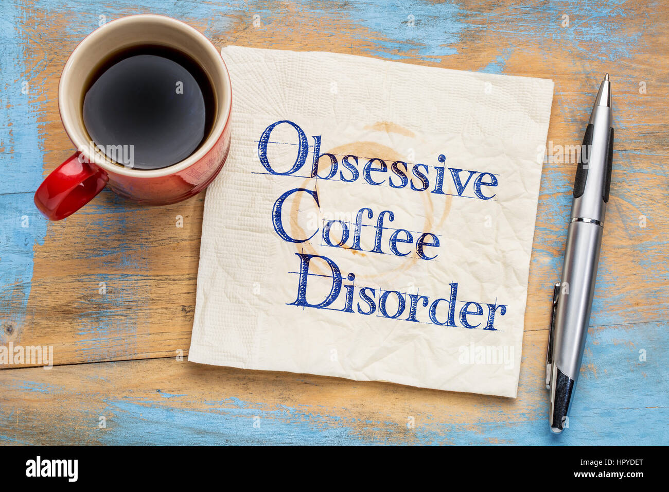 Ossessivo disturbo di caffè (OCD) - scrittura su un tovagliolo con una tazza di caffè Foto Stock