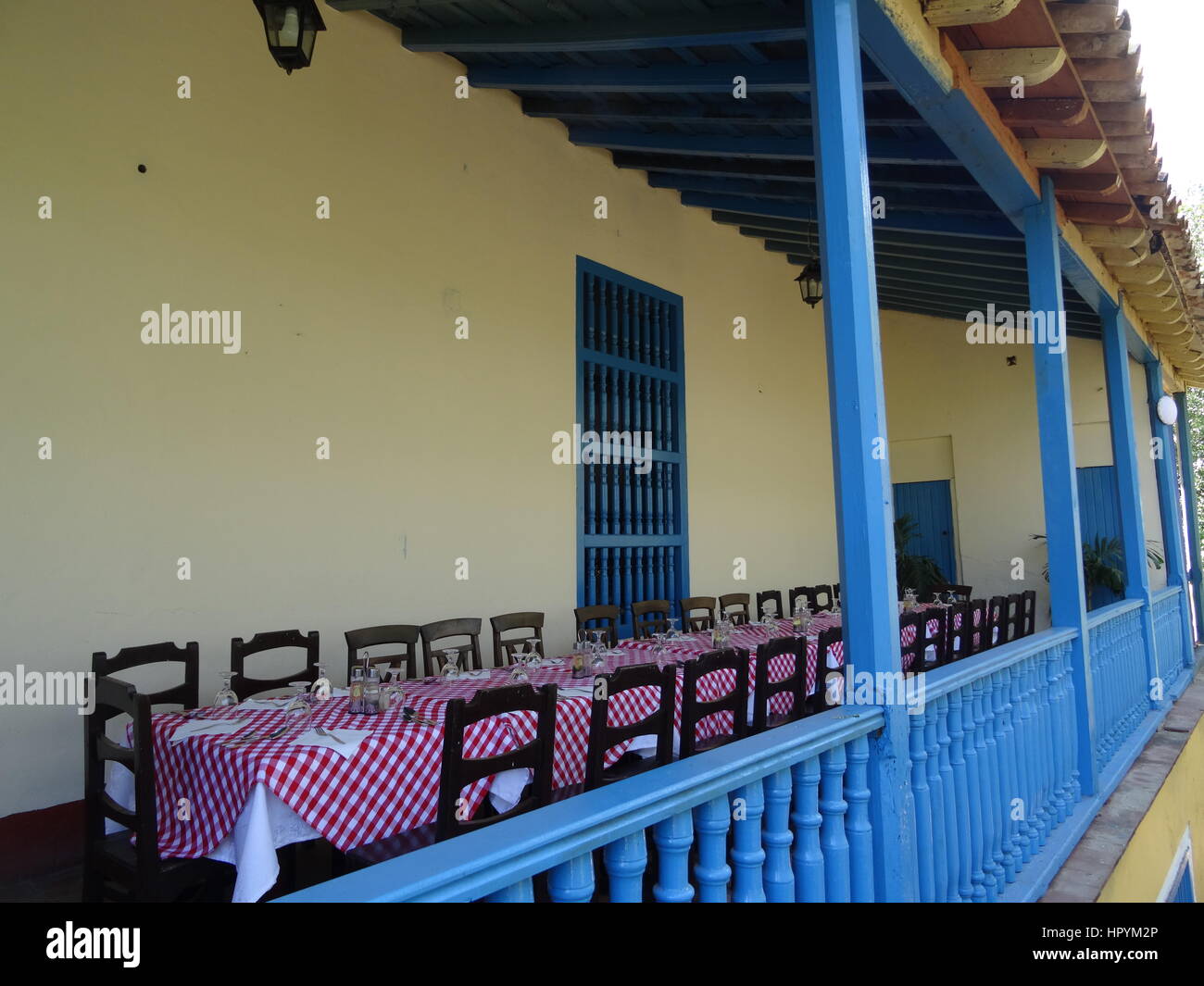 Blue veranda in legno con lunghi impostare la tabella in una canna da zucchero piantagione hacienda e la Valle de los Ingenios, Cuba Foto Stock