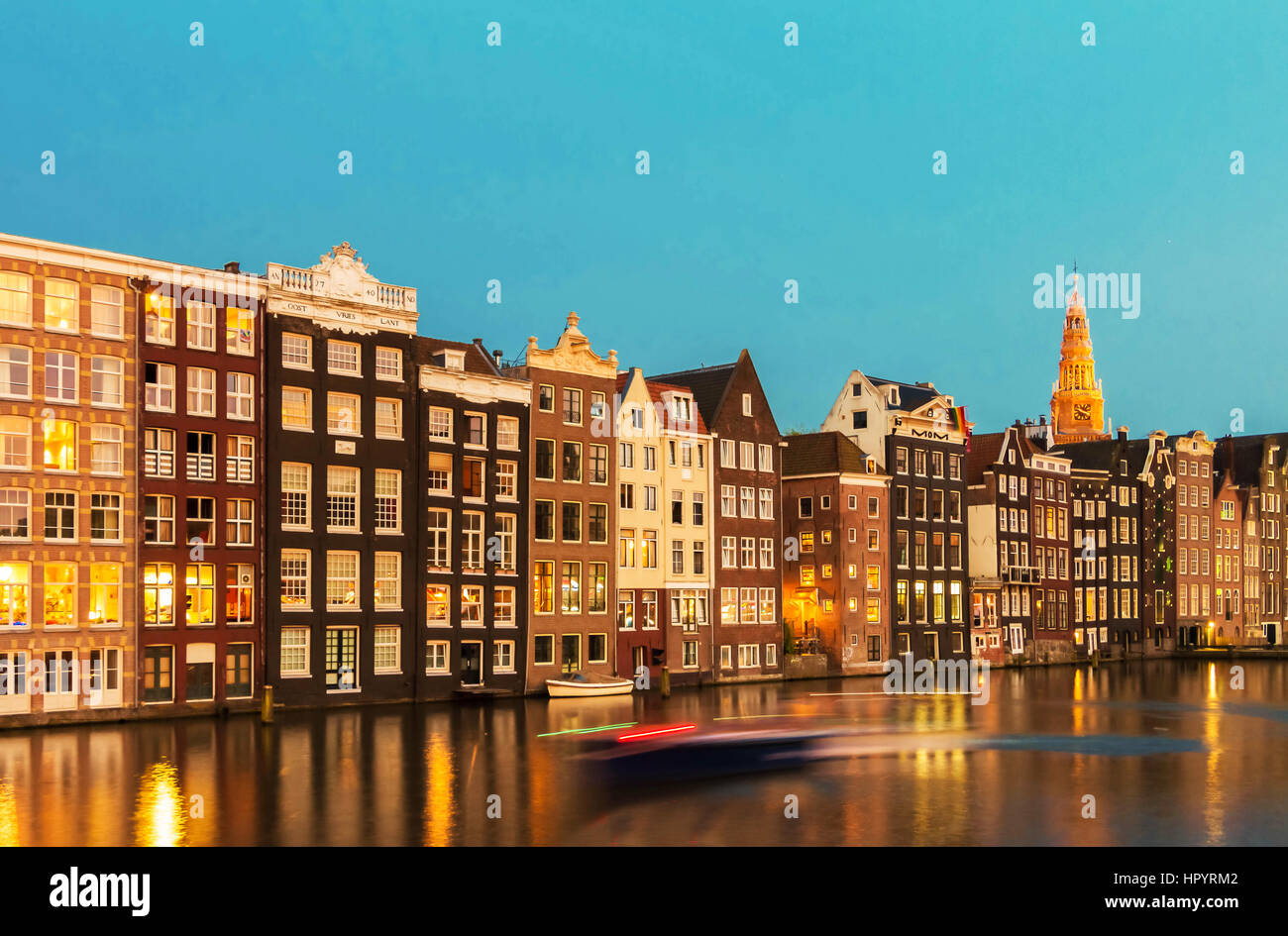 Facciate di case su canal con riflessioni illuminata di notte, Amsterdam, Paesi Bassi. Foto Stock