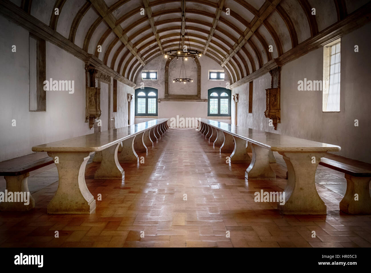 Vecchia sala da pranzo con un marmo lunghi tavoli e panche in un monastero Foto Stock