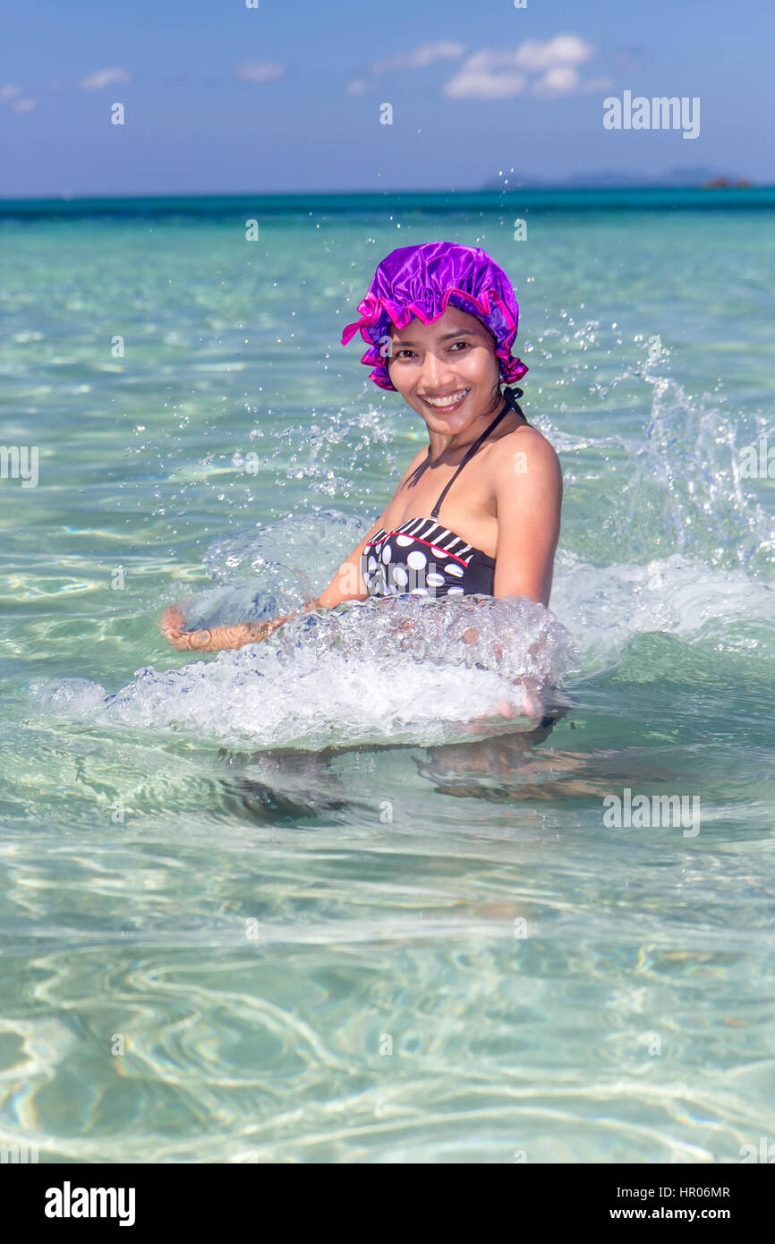 https://c8.alamy.com/compit/hr06mr/allegra-donna-in-costume-da-bagno-retro-e-cuffia-da-bagno-spruzzi-di-acqua-in-un-mare-trasparente-vacanza-tropicale-hr06mr.jpg