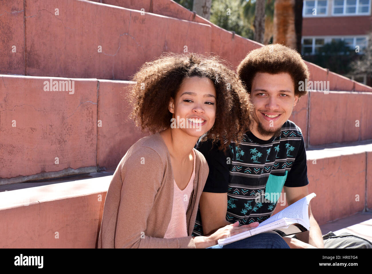 Una giovane donna e uomo con libri e elettronica su un campus universitario. Foto Stock