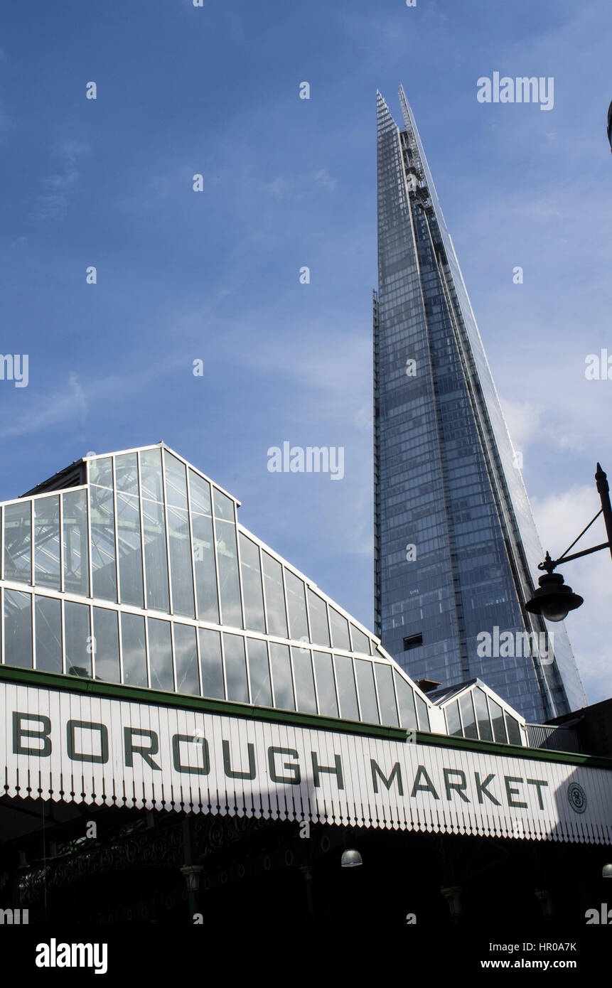 Il tetto del Mercato di Borough con segnaletica e il Coccio in background contro un cielo blu con ciuffi di nuvole Foto Stock