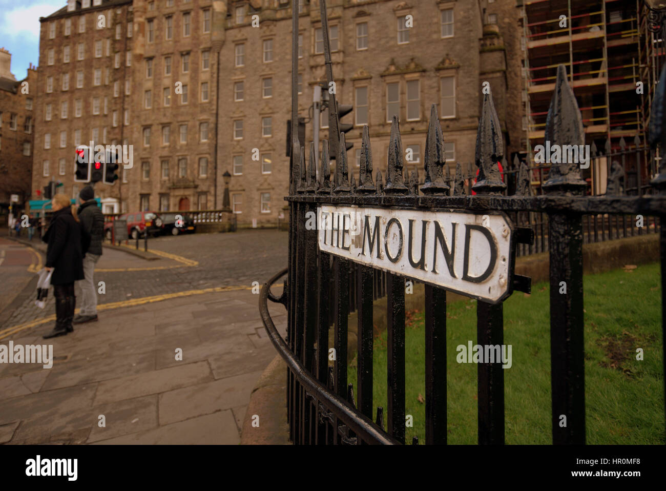 Edinburgh il tumulo turisti camminando sulla strada segno sulle ringhiere Foto Stock