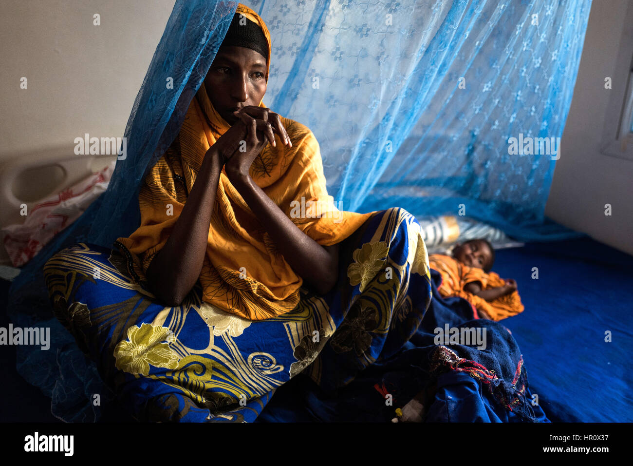 Haua Youssuf Ali è seduto con le sue due figlie su un letto di ospedale a Garowe, capitale del Puntland parte del nord-est della Somalia, 23 febbraio 2017. I tre-anno-vecchio Hamdi, chi è gravemente malnutriti, è qui per la seconda volta. Intanto la sua sei-mese-vecchio sorella Fatima è anche in corso di trattamento. Entrambi sono affetti da diarrea, vomito e perdita di appetito: effetti collaterali tipici in bambini che soffrono di malnutrizione. Alcuni 6.2 milioni di persone in Somalia sono dipendente dagli aiuti umanitari a seguito di una grave siccità. Non ci dovrebbe essere nessun rapido sollievo, il Paese del Corno d Africa è unde Foto Stock