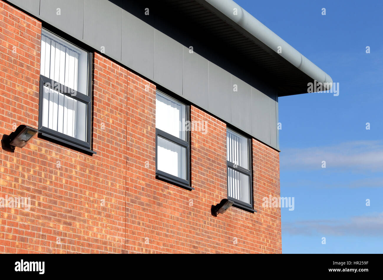 Angolo del moderno mattone edificio per uffici con cielo blu sullo sfondo. Foto Stock