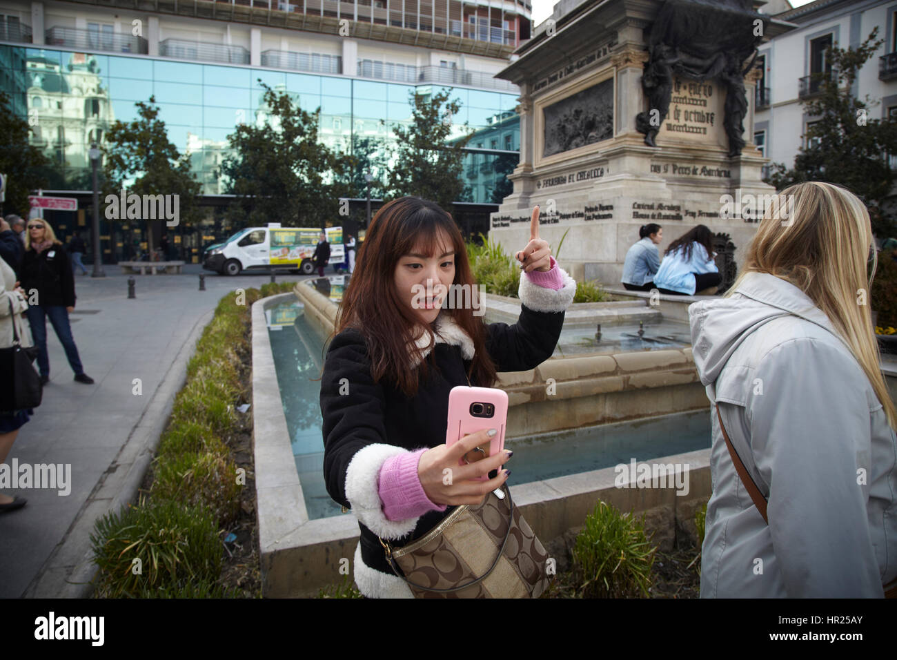 Una ragazza prendere un selfie di fronte alla regina Isabelle e Cristopher Columbus in Granada. Spagna Foto Stock