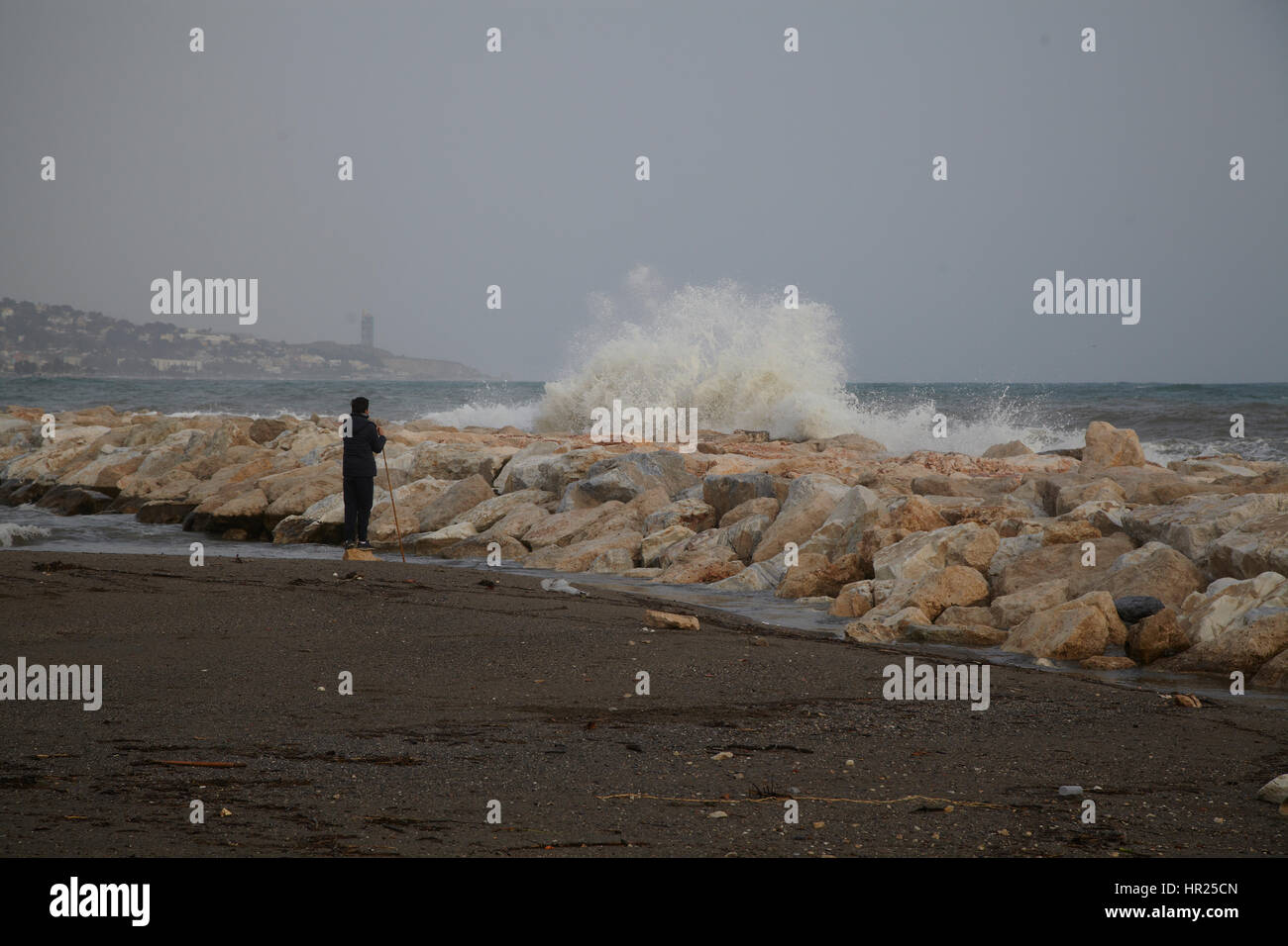 Un ragazzo alla ricerca quando una grande onda incontra un frangiflutti. Malaga. Spagna Foto Stock