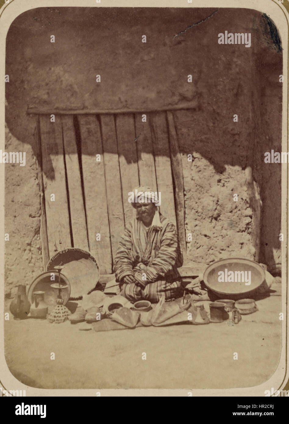 L'immagine intitolata "Peddling. Vendendo articoli in ghisa" rappresenta un venditore ambulante che vende articoli da ferro. La scena evidenzia il lavoro quotidiano dei commercianti di strada del XIX secolo, sottolineando il contesto socio-economico del periodo. Foto Stock