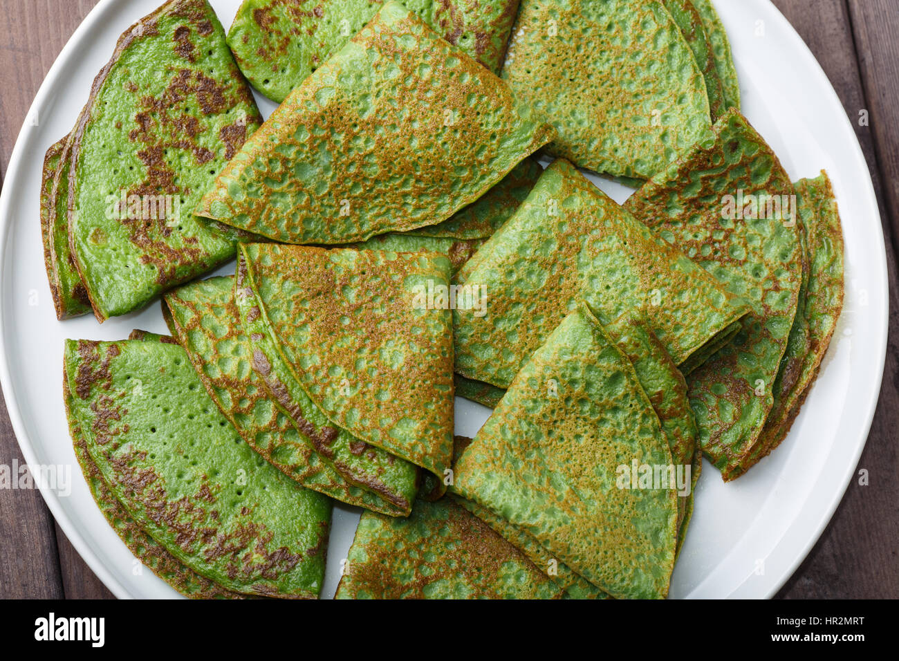 Frittelle di spinaci su piastra bianca. Sullo sfondo la prima colazione Foto Stock