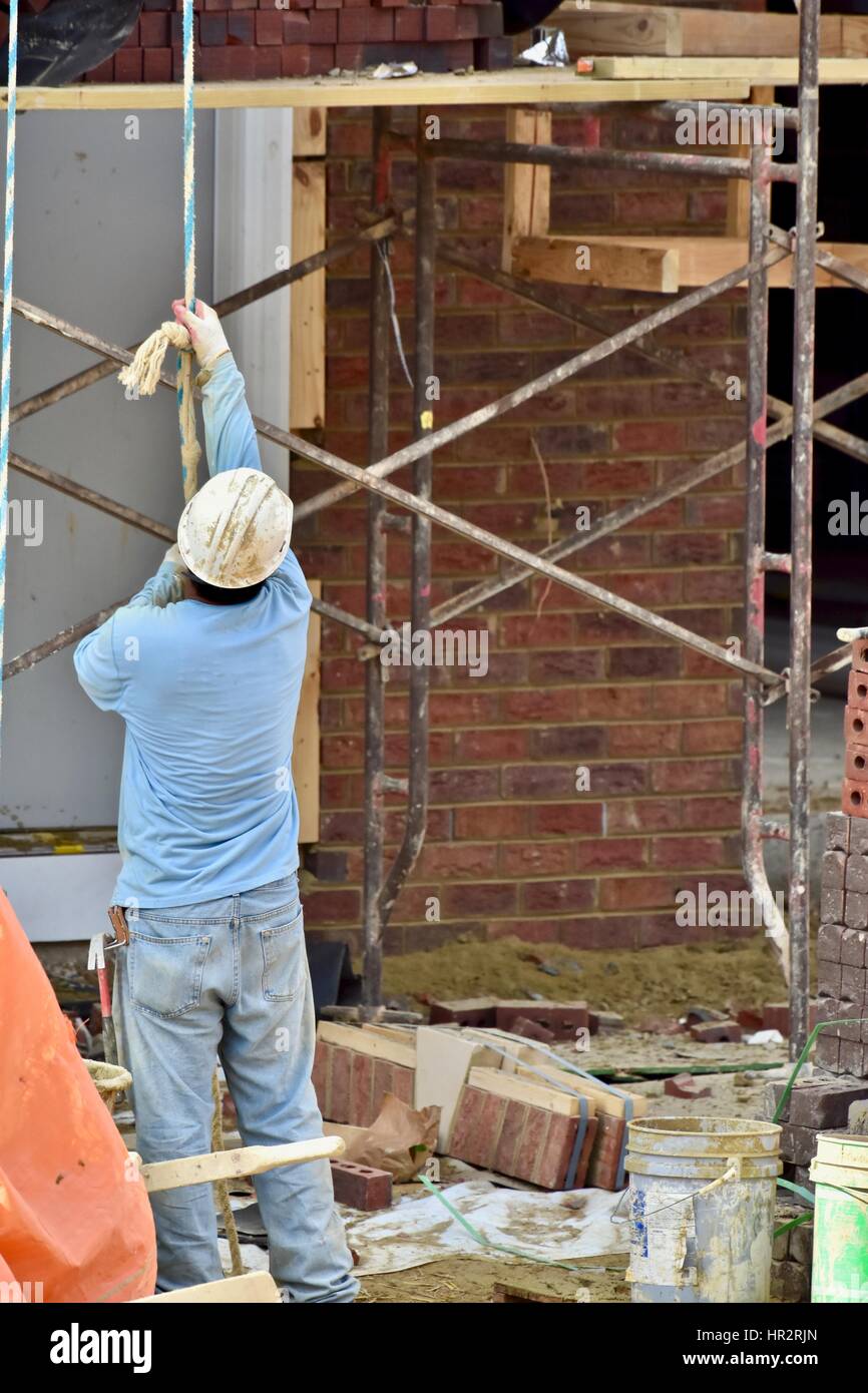 Lavoratori edili mettendo il schierandosi su una nuova casa Foto Stock