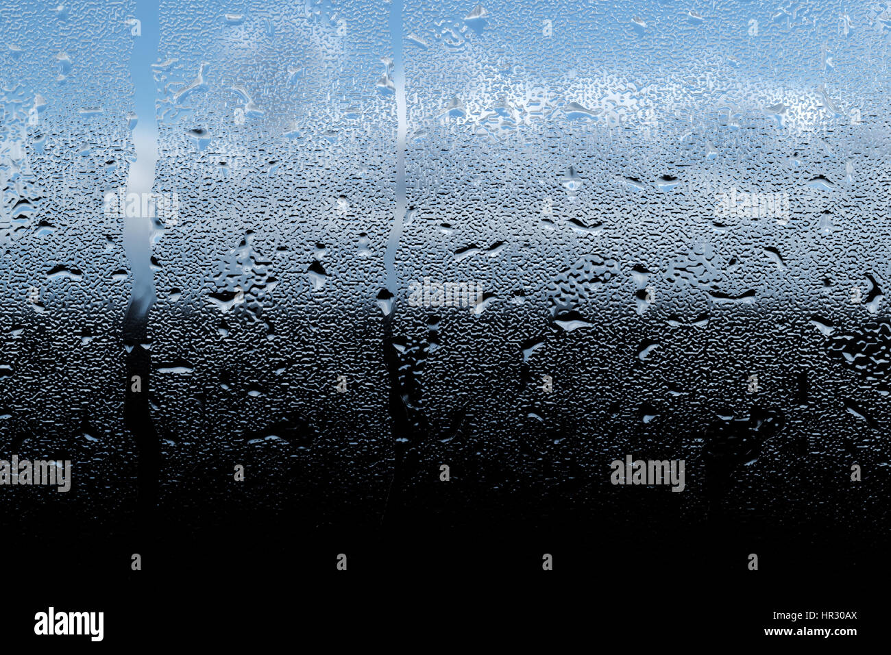 Le gocce di pioggia a sunrise su una finestra Foto Stock