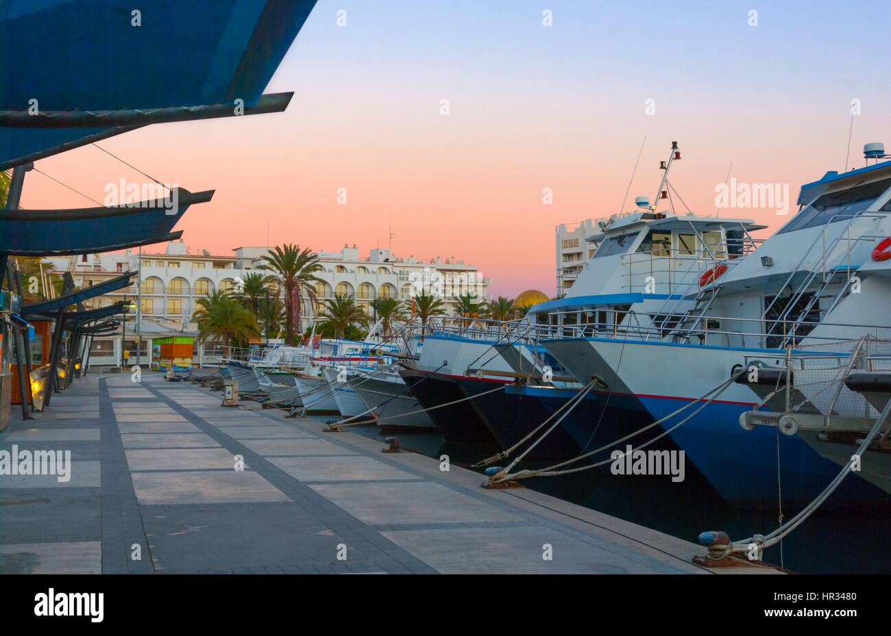 Barche in per la sera nel porto Marina sotto drammatico tramonto magenta colore . Fine di un giorno caldo e soleggiato in Ibiza, Sant Antoni de Portmany, Spagna. Foto Stock