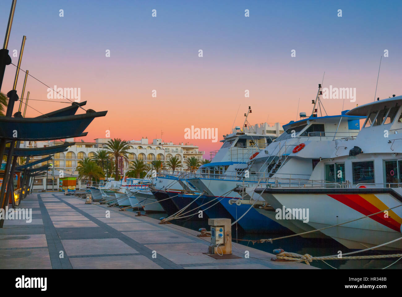 Barche in per la sera nel porto Marina sotto drammatico tramonto magenta colore . Fine di un giorno caldo e soleggiato in Ibiza, Sant Antoni de Portmany, Spagna. Foto Stock